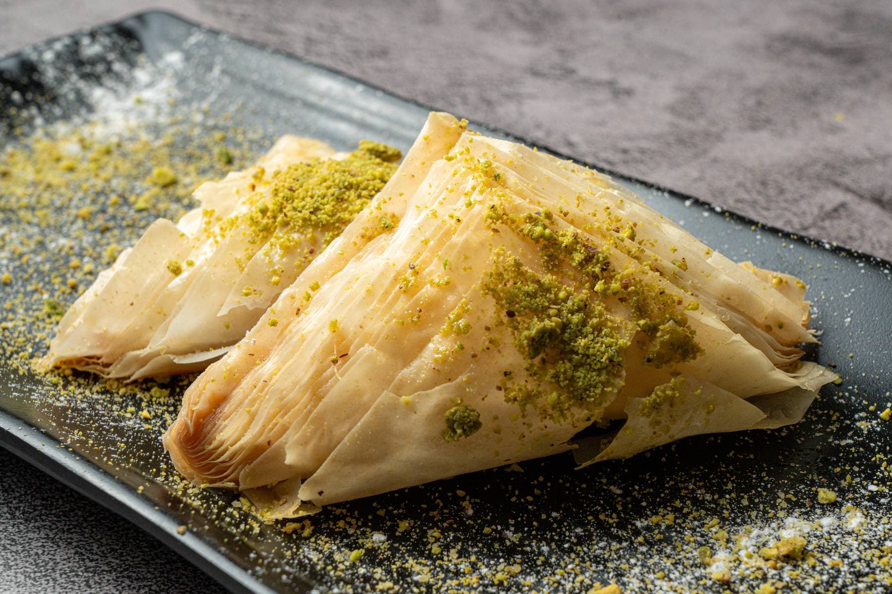 Pistachio-dusted baklava, layers of crisp golden phyllo finished with crushed pistachio