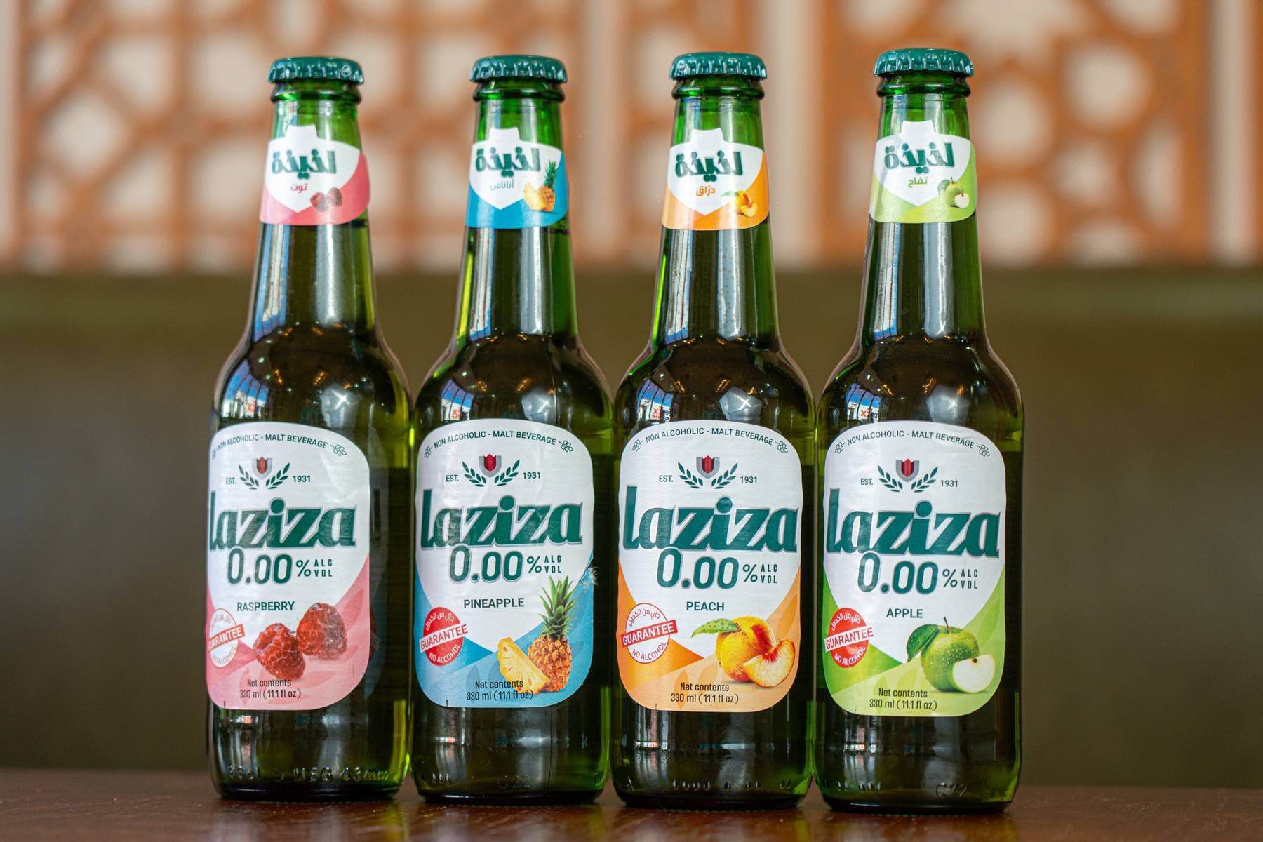 A lineup of Laziza non-alcoholic malt beverages — raspberry, pineapple, peach, and apple — chilled and ready to pour