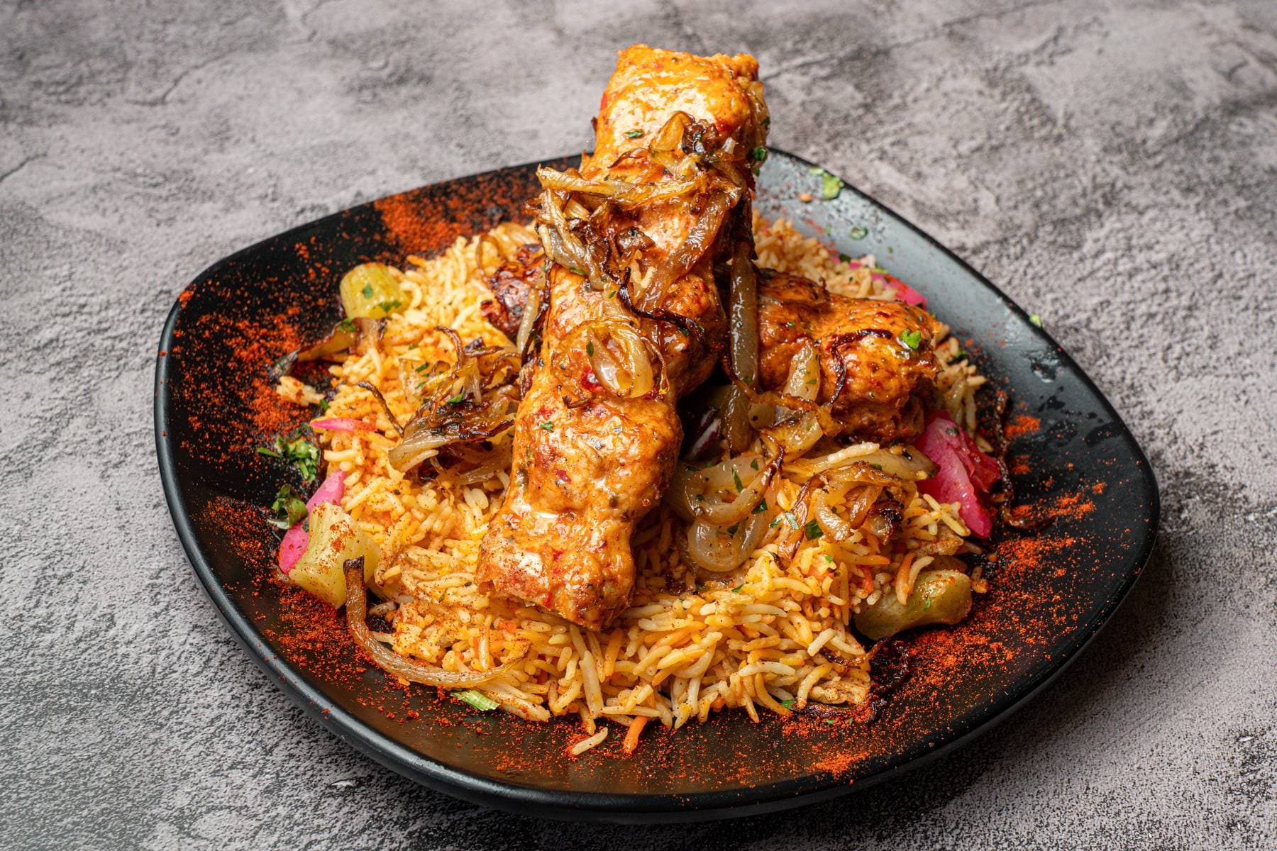 Shish tawook skewers, marinated grilled chicken stacked over Egyptian rice with onions and pickled veggies